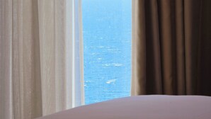 A room with a bed and a view of the sea through sheer curtains. - Valza Boutique Hotel (Vlorë)
