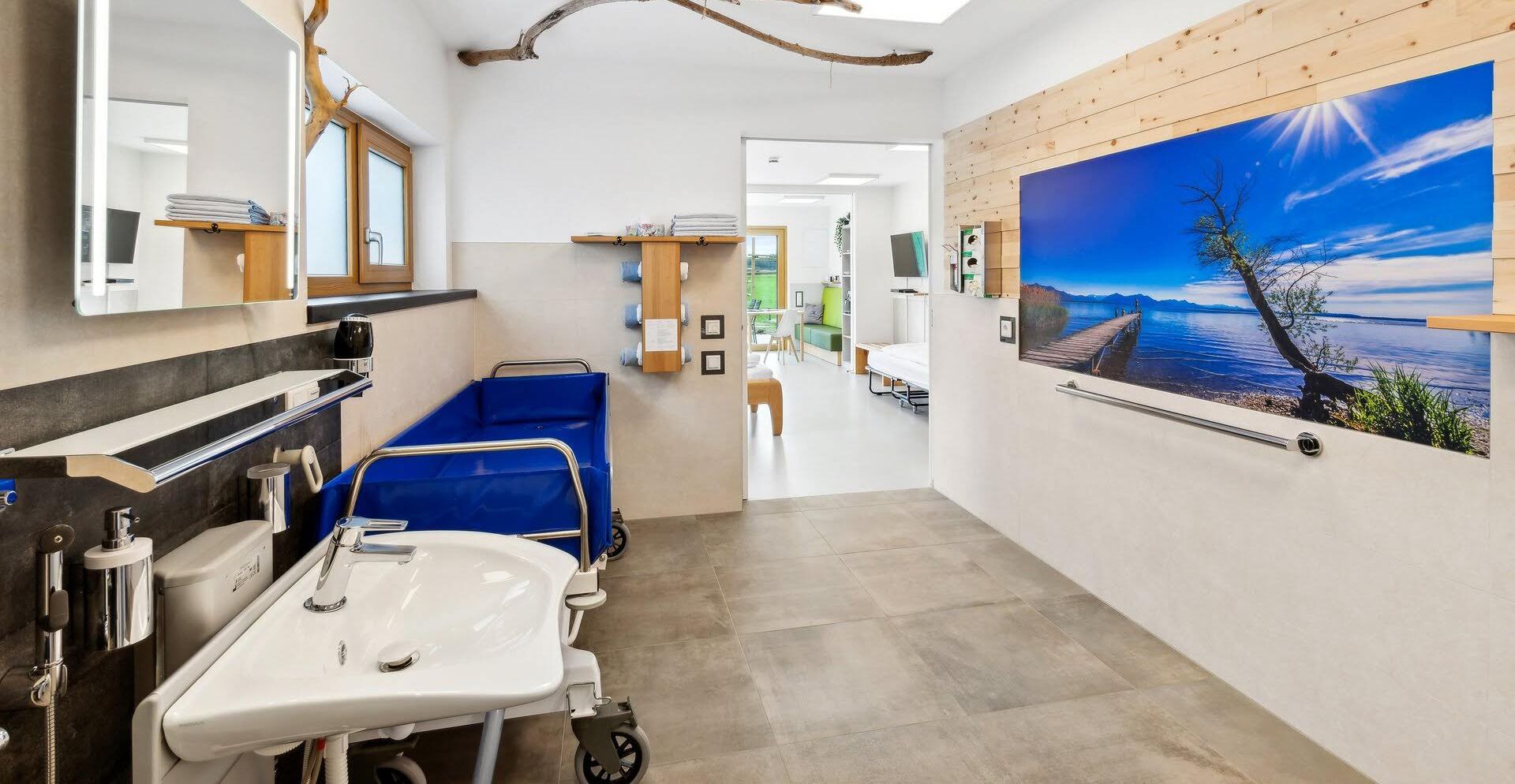 Un baño moderno con lavamanos, espejo y bañera azul.