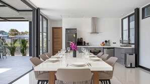 Een moderne eetruimte met een grote tafel voor zes personen, omringd door stoelen.