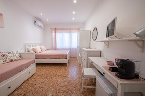 A bedroom with a bed, a desk, a chair, a wardrobe, a mirror, and a television. - Casa Rosa Beige e Blu (Rome)