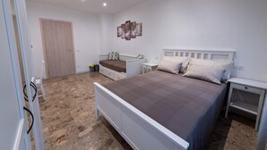 A bedroom with a bed, bedside tables, a wardrobe, and a door. - Casa Rosa Beige e Blu (Rome)