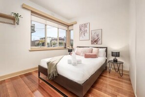 2 habitaciones, escritorio y tabla de planchar con plancha