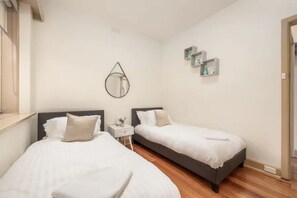 2 habitaciones, escritorio y tabla de planchar con plancha