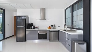 Une cuisine moderne équipée d’appareils électroménagers en acier inoxydable, d’un lave-vaisselle et d’un four encastré.