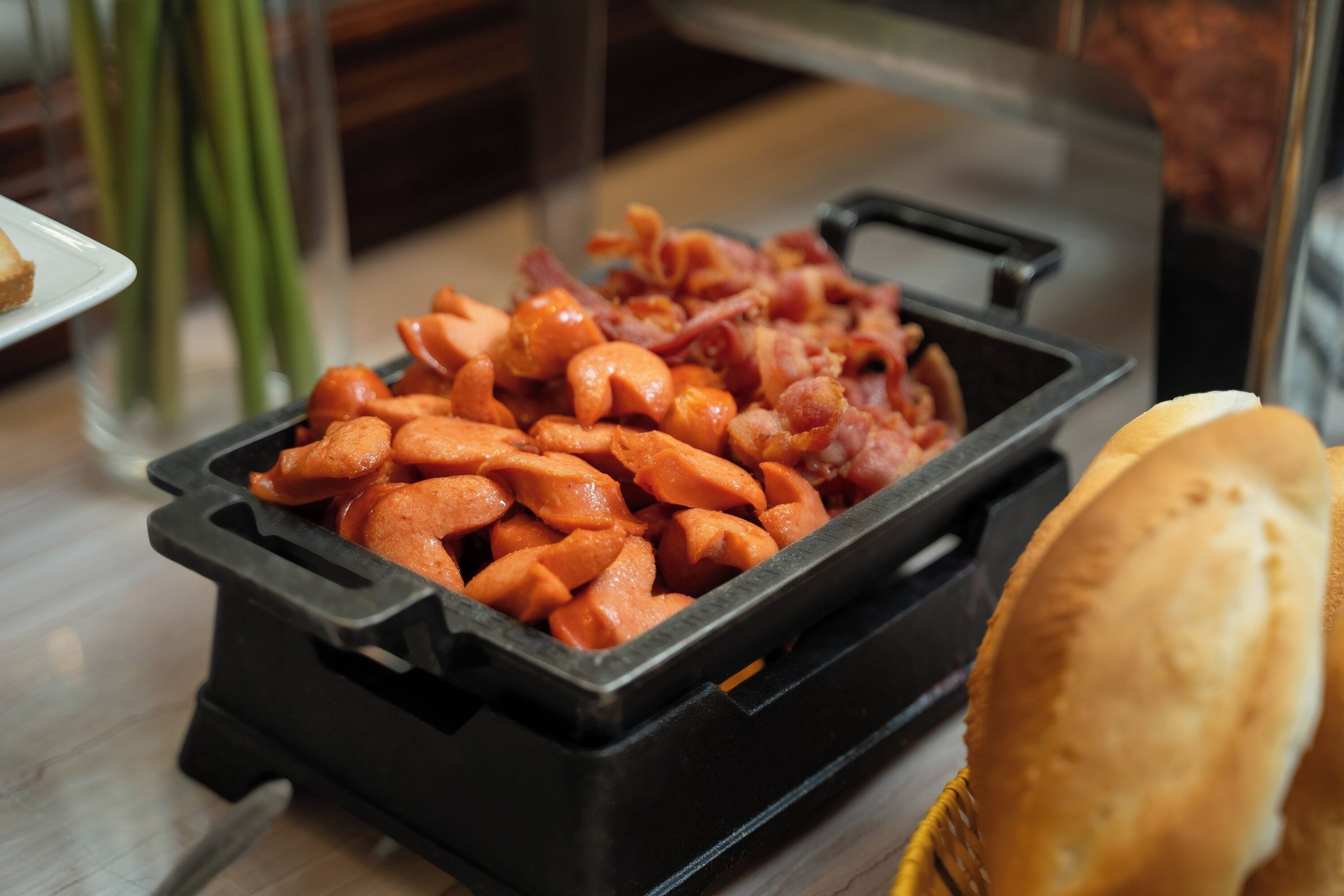 A buffet with various food items including carrots and bacon.