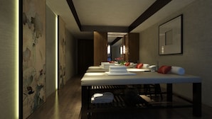 A modern hotel lobby with a long reception desk, plush seating, and traditional artwork on the walls. - The West Hotel & Spa (Hanoi)