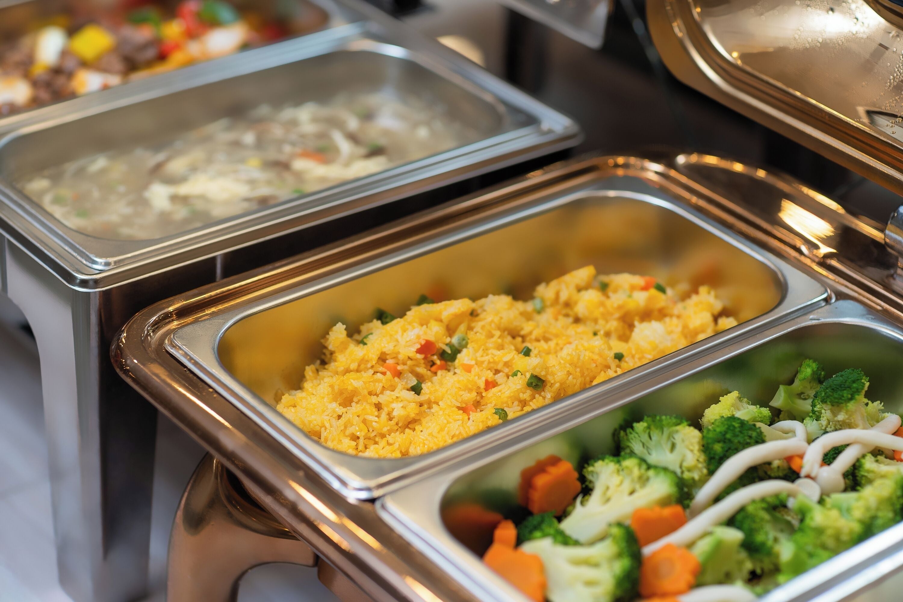 A buffet with various food options including rice, vegetables, and a soup dish.