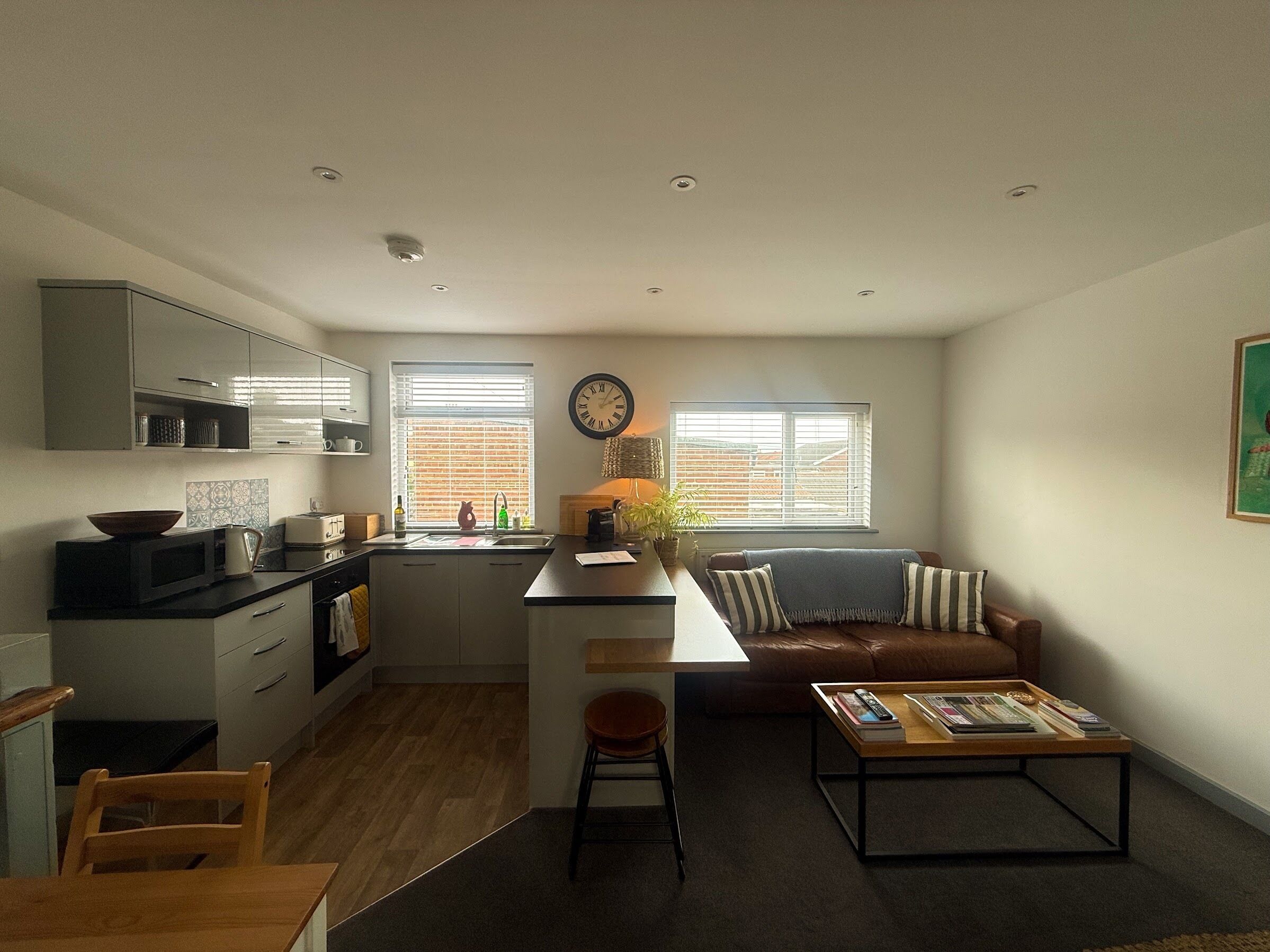 A compact living space with a kitchenette, a dining area, a sofa, and a coffee table.