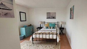 Quarto com uma cama, duas mesas de cabeceira, um penteado e um tapete.
