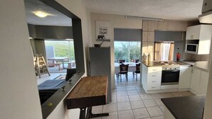 Uma cozinha compacta com área de refeições, geladeira, micro-ondas e fogão.