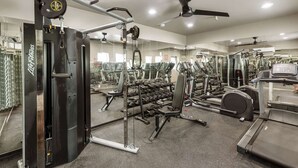 A gym with various exercise equipment, including weight machines, treadmills, and dumbbells. - Hinny's sweet suite w/ Heated Pool, GYM & Hot Tub (Scottsdale)