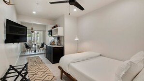 A modern bedroom with a bed, a desk, and a television. - Cuddy's sweet suite W/ Heated Pool, GYM & Hot Tub (Scottsdale)