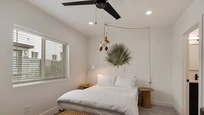 A bedroom with a bed, bedside tables, a hanging plant, a ceiling fan, and a window with blinds. - Burro's sweet suite W/ Heated Pool, GYM & Hot Tub (Scottsdale)