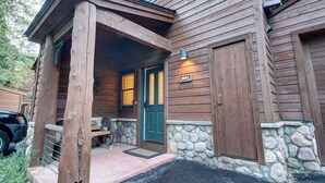 A wooden cabin with a stone foundation, a porch with a bench, and a door marked "1992". - Starfire 1992 (Keystone)