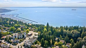 Ett flygbildsfoto av en kuststad med bostadshus, en småbåtshamn och en stor vattenyta.