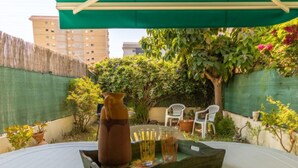 A patio area with a table set for two, a pitcher, and glasses. - Vacation home Boters by Interhome (Torredembarra)