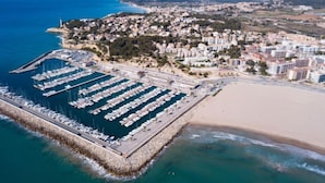An aerial view of a coastal town with a marina, beach, and residential buildings. - Vacation home Boters by Interhome (Torredembarra)