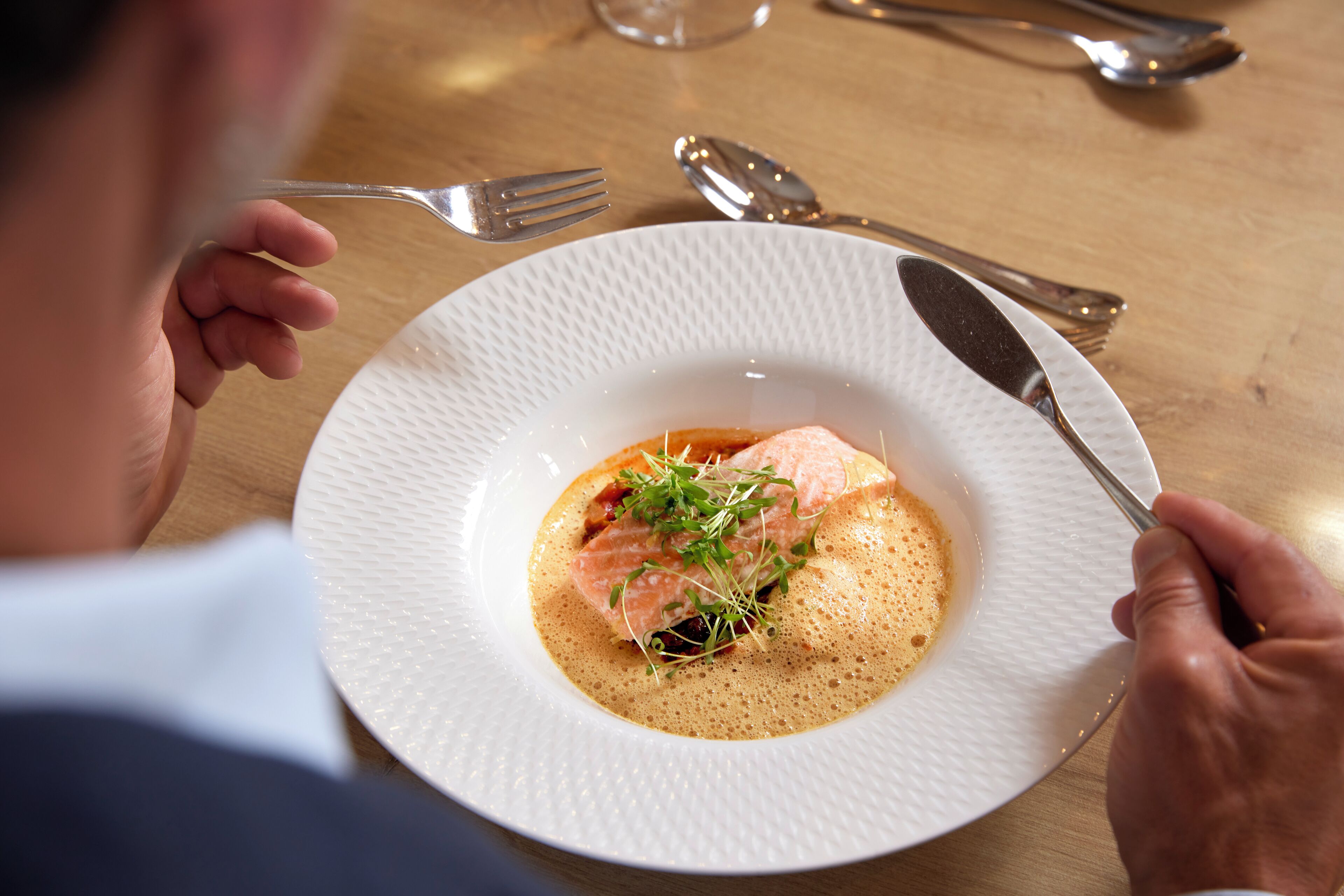 Une assiette de nourriture, avec une fourchette et un couteau, posée sur une table en bois.