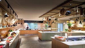 A modern kitchen with a central island, various cooking utensils, and a chalkboard menu. - Panoramahotel Oberjoch (Bad Hindelang)