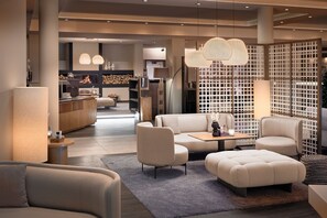 A modern living room with a sofa, ottoman, and a coffee table.
