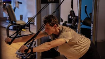 A person using a resistance band exercise machine in a gym.