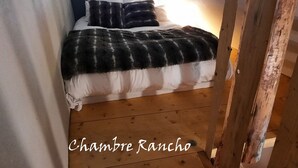 A bedroom with a bed, pillows, and a blanket. The room has wooden flooring and a window. - Comfort 2-room, 6 ppl, Terrace & Garden in Valloire (Valloire)