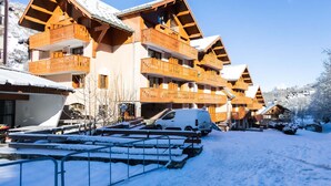 A snow-covered building with multiple balconies and a parking area. - Studio cabin + mezzanine for 4, West-facing balcony in Valloire (Valloire)