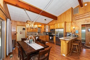 Un intérieur en bois comprenant un coin repas, une cuisine et un bar.