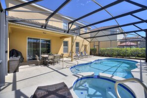 An indoor swimming pool with a glass ceiling, surrounded by lounge chairs and a table. - The Cinehaven at Solterra by Shine Villas 407 (Davenport)
