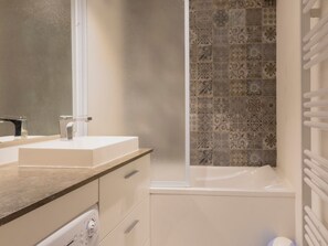 A bathroom with a white sink, a mirror, a shower with patterned tiles, and a white towel rack. - 2-room cabin south apartment in Valloire, 4 pers, pets allowed (Valloire)