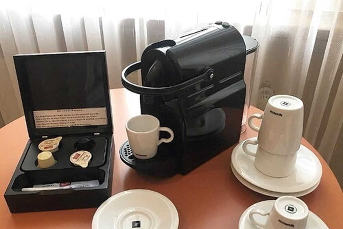 A coffee maker, a mug, and a tea set on a table.