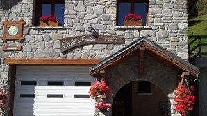 A stone building with a sign reading "Chalet des Ancolies."