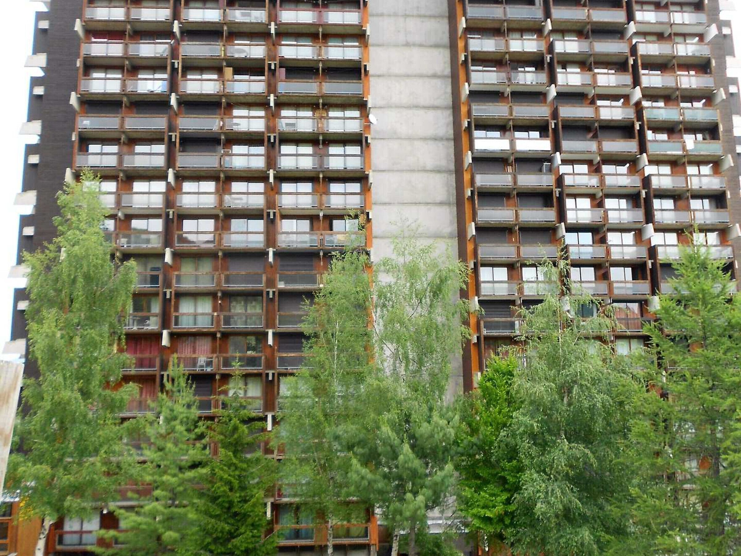 Ein Hochhaus mit zahlreichen Balkonen und einem zentralen Kern.