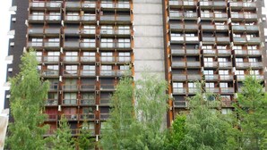 A high-rise building with multiple balconies and a central core.