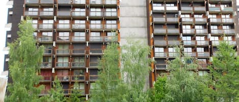Un immeuble de grande hauteur doté de nombreux balcons et d’un noyau central.