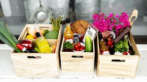 Three wooden crates filled with various groceries and flowers. - Moens Motell (Vanylven)