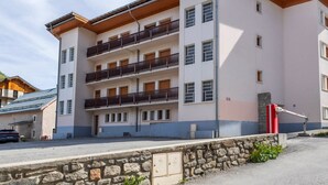 A multi-story hotel with balconies, a stone wall in front, and a clear sky. - 2-room apartment for 6 people south-facing in Valloire (Valloire)