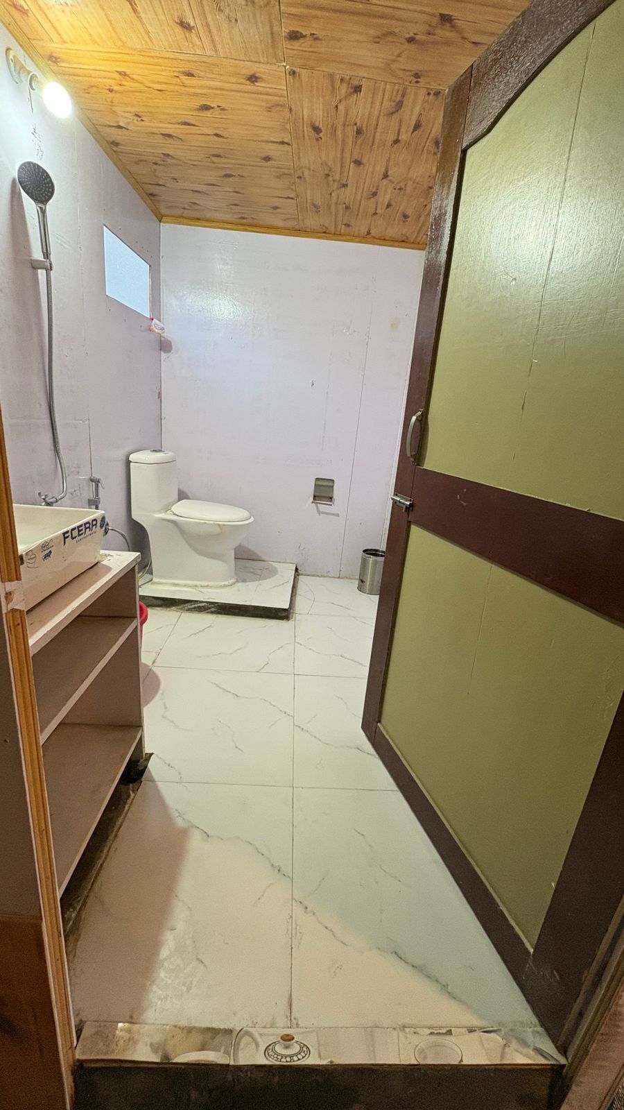 A bathroom with a toilet, a sink, and a shower area.