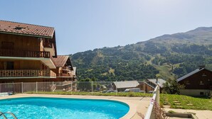 Un espace piscine offrant une vue dégagée sur un paysage montagneux en arrière-plan.