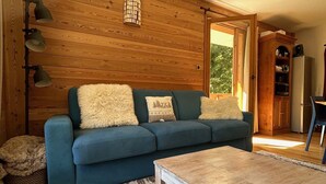 Un salon chaleureux avec un canapé bleu, des coussins moelleux, une table basse en bois et un tapis à motifs.