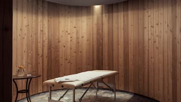 Une pièce aux murs lambrissés, comprenant une table de massage, une petite table avec un verre et un vase, et un sol imitant la pierre.
