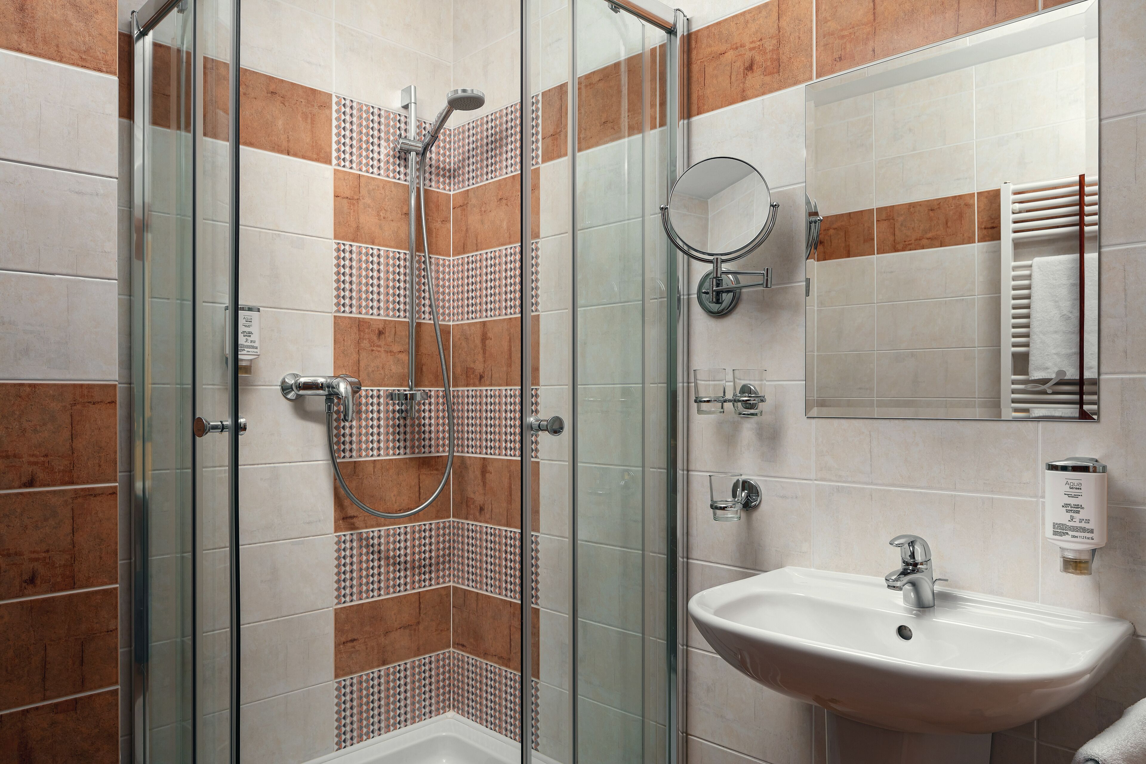 Un baño con ducha de vidrio, lavamanos y espejo.
