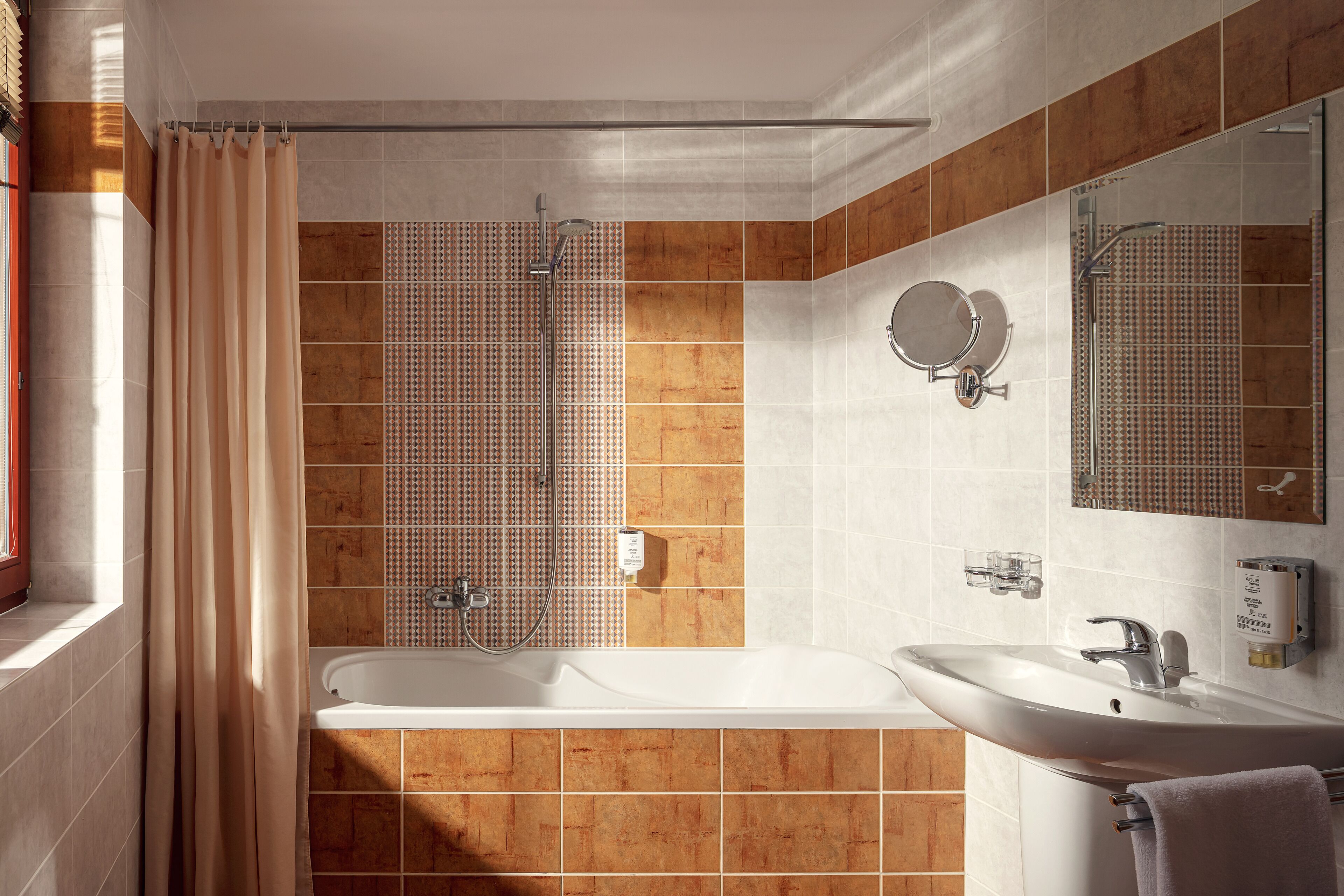A modern bathroom with a bathtub, shower, and sink.