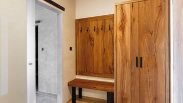 Um corredor com um banco de madeira e um guarda-roupa com várias portas.