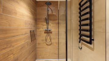 A modern shower area with wooden walls and a glass partition.