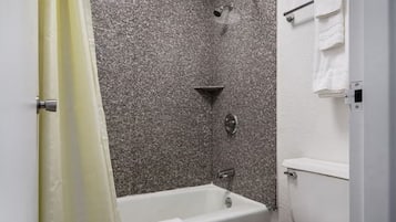 Un baño con bañera, ducha e inodoro.