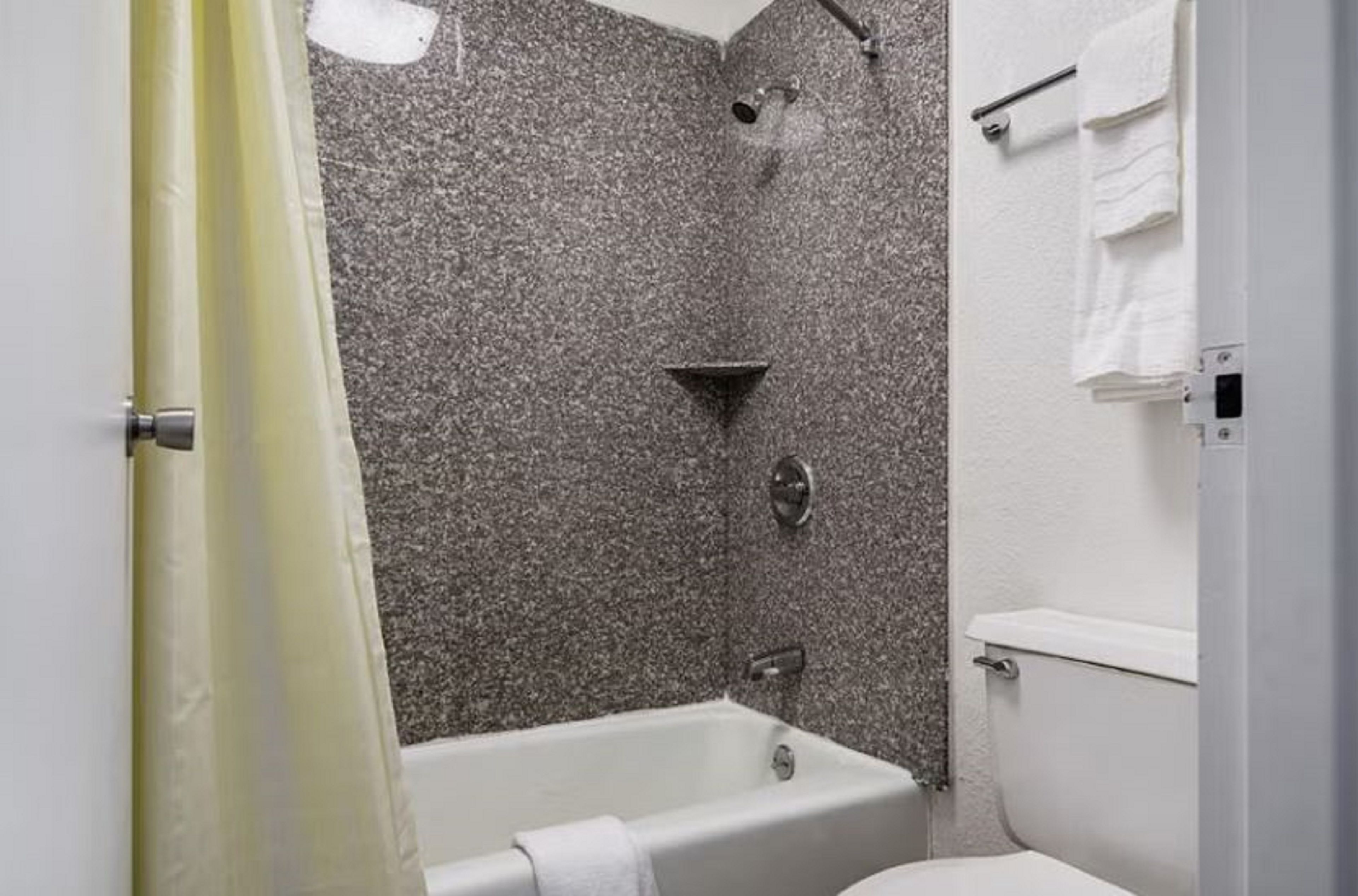 Un baño con bañera, ducha e inodoro.