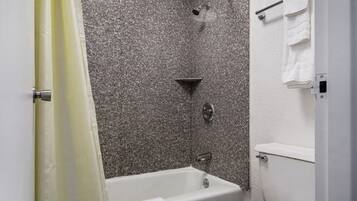 Un baño con bañera, ducha e inodoro.