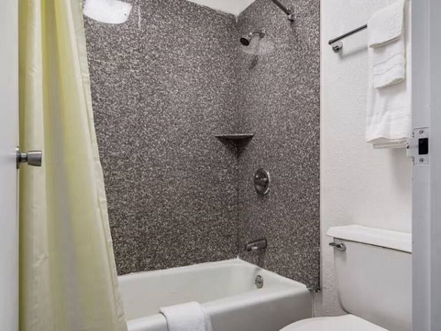 Un baño con bañera, ducha e inodoro.