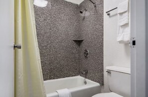 Un baño con bañera, ducha e inodoro.